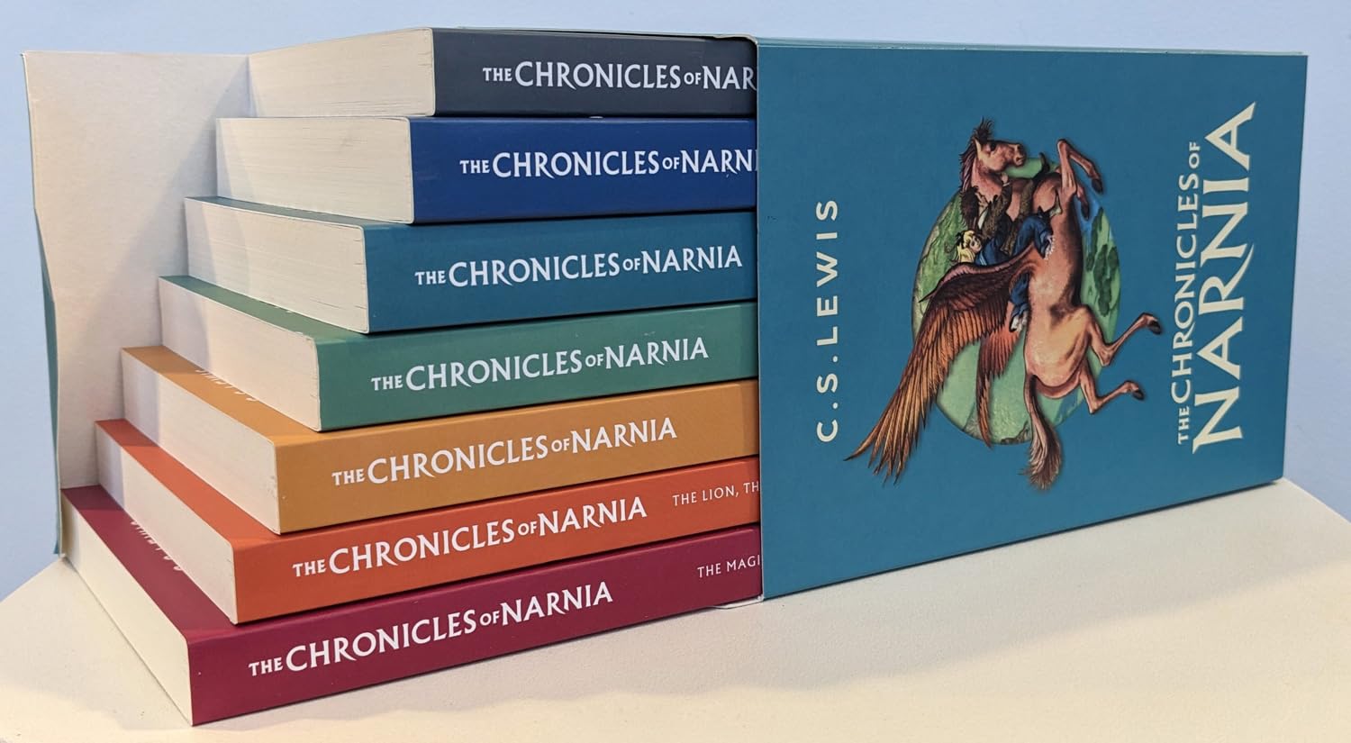 The Chronicles of Narnia box set – all 7 colorful books displayed in a staircase layout beside the illustrated outer slipcase