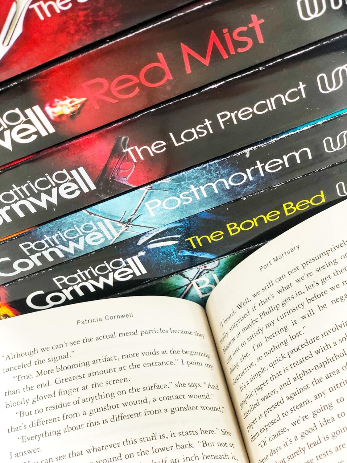 Stack of books by Patricia Cornwell with an open book in the foreground.