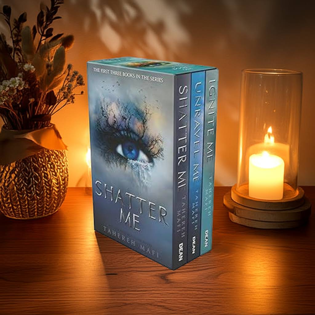 Shatter Me 3 Book Box Set by Tahereh Mafi on a wooden table with candlelight, warm background and cozy atmosphere