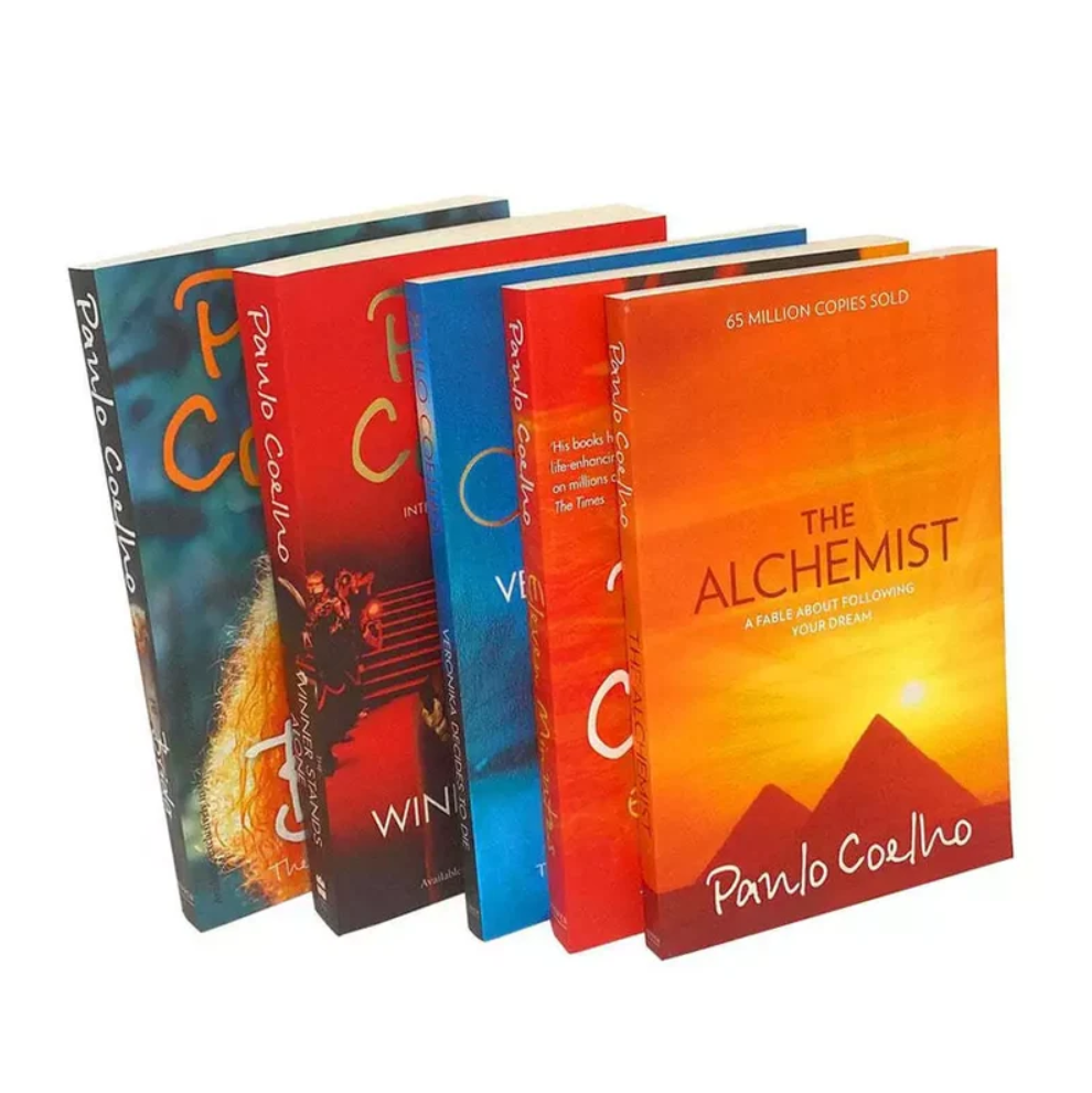 Four copies of the book 'The Alchemist' by Paulo Coelho fanned out against a white background, showing different colored edition covers.