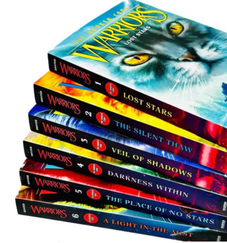 Stack of 'Warriors' books with colorful covers on a white background