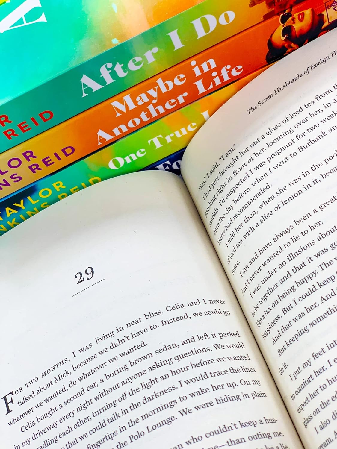 Open book with rainbow-colored books stacked on top